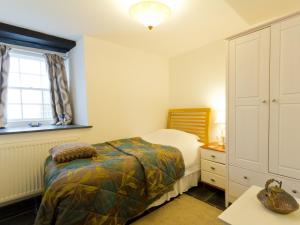 Un dormitorio con una cama y una cómoda y una ventana. en Museum Apartment, en Looe