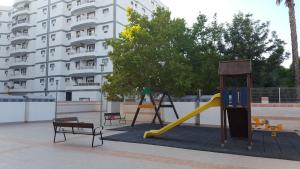 un parque infantil con tobogán y columpio en appartement avec piscine, en San Vicente del Raspeig
