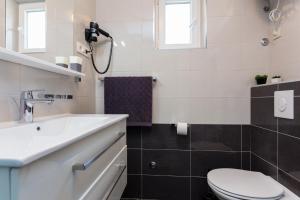 uma casa de banho branca com um lavatório e um WC em Guesthouse Ivona em Dubrovnik