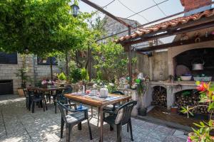 a patio with tables and chairs and a fireplace at Guesthouse Ivona in Dubrovnik