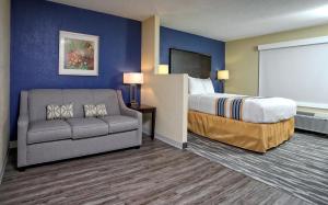 pokój hotelowy z łóżkiem i kanapą w obiekcie Eagles Nest Inn w mieście Statesboro