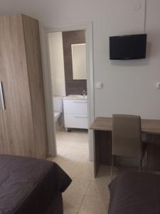 1 dormitorio con cama, escritorio y baño en Hotel Venta Nueva, en Calatañazor