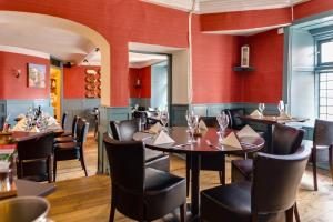 un ristorante con tavoli, sedie e pareti rosse di The Ancient Gatehouse & Rugantino Restaurant a Wells