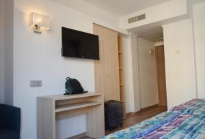 a bedroom with a bed and a tv on a wall at Hotel Tropic in Cala de Finestrat