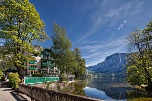 ein Gebäude an der Seite eines Flusses mit einem Berg in der Unterkunft Seevilla Altaussee in Altaussee