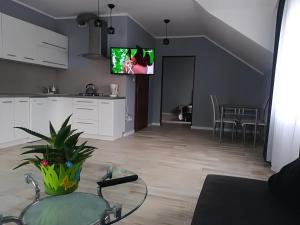a living room with a table and a tv on the wall at Apart-noclegi in Siemiatycze