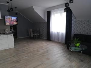 a living room with a table and a television at Apart-noclegi in Siemiatycze +17 photos