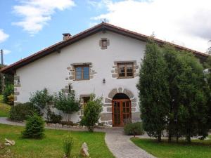 duży biały dom z drzwiami na dziedzińcu w obiekcie Hotel Rural Natxiondo w mieście Lekeitio
