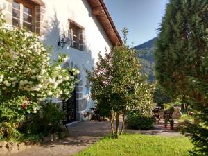 biały budynek z drzewami przed nim w obiekcie Hotel Rural Natxiondo w mieście Lekeitio