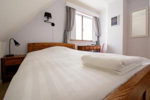 uma cama branca num quarto com uma janela em 'T Buskruid Hotel em Lummen