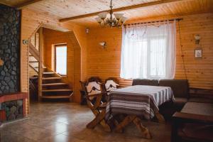 - une salle à manger avec une table et des chaises dans une cabine dans l'établissement Kryvyi brid, à Yaremtche