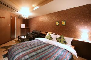 Habitación de hotel con cama y silla en Hotel Aura Resort Ⅱ Kashiba (Adult Only), en Nara