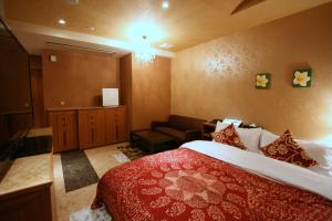 Habitación de hotel con cama y sofá en Hotel Aura Resort Ⅱ Kashiba (Adult Only), en Nara