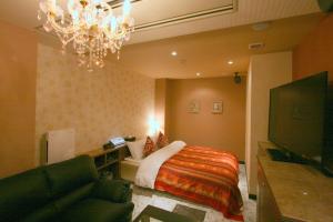 Habitación de hotel con cama y lámpara de araña. en Hotel Aura Resort Ⅱ Kashiba (Adult Only), en Nara