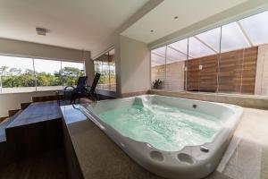 a large bath tub in a room with windows at Serra Madre Hotel in Rio Quente