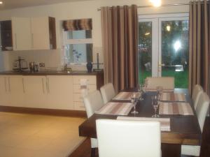 a kitchen with a table with white chairs and a dining room at 33 ArdMullen Townhouse X Davitt's Guesthouse & Restaurant Kenmare in Kenmare