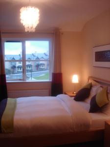a bedroom with a large bed and a window at 33 ArdMullen Townhouse X Davitt's Guesthouse & Restaurant Kenmare in Kenmare