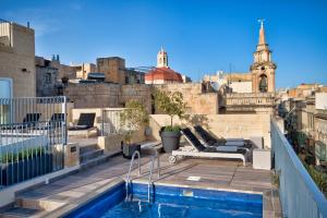 eine Dachterrasse mit einem Pool auf einem Gebäude in der Unterkunft 66 Saint Paul's & Spa in Valletta