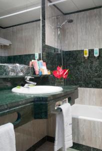 a bathroom with a sink and a bath tub at Abba Playa Gijón in Gijón