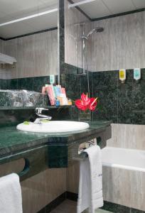 ein Badezimmer mit einem Waschbecken und einer Badewanne in der Unterkunft Abba Playa Gijón in Gijón