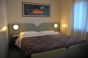 una camera da letto con un grande letto con due luci di Al Fogher a Treviso