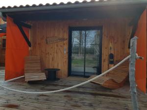 a hammock on the front porch of a cabin at Au Bois Flotté in Hourtin