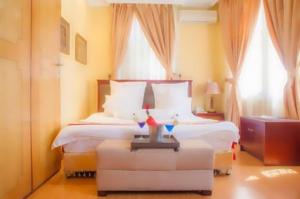 a hotel room with a bed and two windows at Gold Crest Hotel - Arusha in Arusha