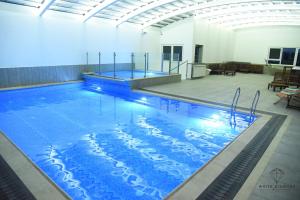 a large swimming pool with blue water in a building at White Diamond in Majdal Shams