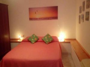 a bedroom with a red bed with two pillows at Appartamento Le Palme in Siniscola