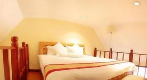 una camera da letto con un grande letto con cuscini bianchi di Gold Crest Hotel - Arusha ad Arusha