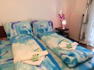 two beds in a room with towels on them at &Iacute;risz Apartman Budapest in Budapest