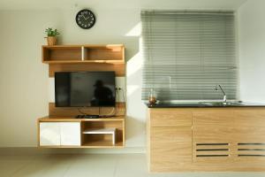 a kitchen with a tv and a sink and a window at JK LIVING Hotel And Service Apartment in Chachoengsao