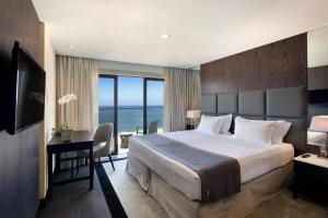 a hotel room with a bed and a desk with a view at Windsor California Copacabana in Rio de Janeiro