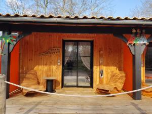 a building with a porch with chairs and a door at Au Bois Flotté in Hourtin
