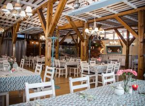 a dining room with white tables and white chairs at Magnolia Pokoje Gościnne in Malbork