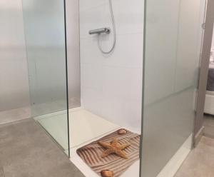 a glass shower stall with a starfish on a towel at Dream Canteras in Las Palmas de Gran Canaria +16 photos