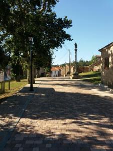 una calle adoquinada con un poste de luz y un árbol en Casa Lola, en Villastose