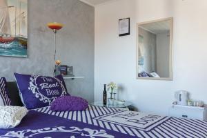 um quarto com uma cama com almofadas roxas e um espelho em Guesthouse Ivona em Dubrovnik