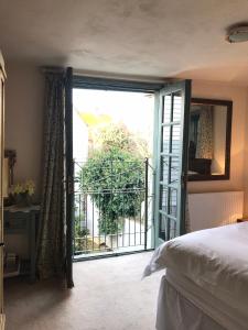 a bedroom with a door open to a balcony at The Tea House in Rye