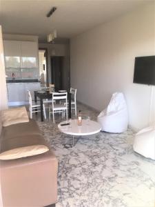 ein Wohnzimmer mit einem Sofa und einem Tisch in der Unterkunft Appartement de 1 à 6 personnes Beaulieu sur mer, climatisé, proche Nice et Monaco tout confort 2 chambres in Beaulieu-sur-Mer