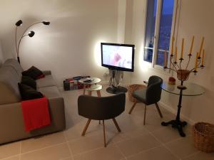 a living room with a couch and a tv and a table at Maison / Appart Le PIOL in Nice