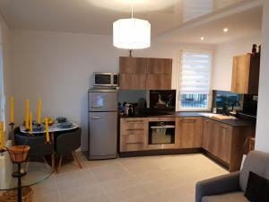 a kitchen with a refrigerator and a table in it at Maison / Appart Le PIOL in Nice