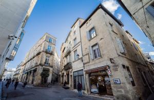 un grupo de edificios en una calle con gente caminando en Le Little Soho, en Montpellier