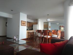 sala de estar y cocina con mesa y sillas en Malecón, en Lima