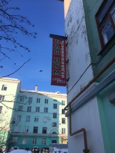 ein Schild an der Seite eines Gebäudes in der Unterkunft Vash Dom Hotel Somova in Murmansk