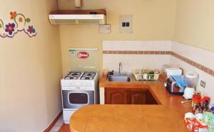 a kitchen with a stove and a sink at Posada Todos Santos in Cuenca