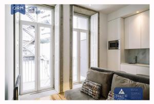 ein Wohnzimmer mit Couch und großem Fenster in der Unterkunft ORM - Mártires & Pinheiro Apartments in Porto