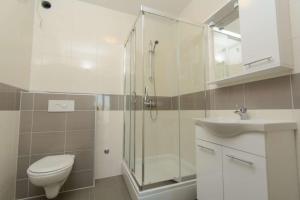 een badkamer met een douche, een toilet en een wastafel bij Ivana in Trogir