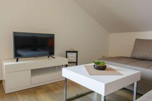 een woonkamer met een tv en een witte salontafel bij Ivana in Trogir