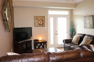 a living room with a leather couch and a television at River Crossing Resort in Pigeon Forge